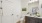 A white bathroom with a toilet, sink, and a painting on the wall.