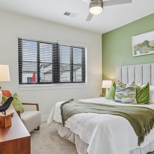 B2A Model Bedroom  A bedroom with a large bed, a wooden side table, and a ceiling fan.