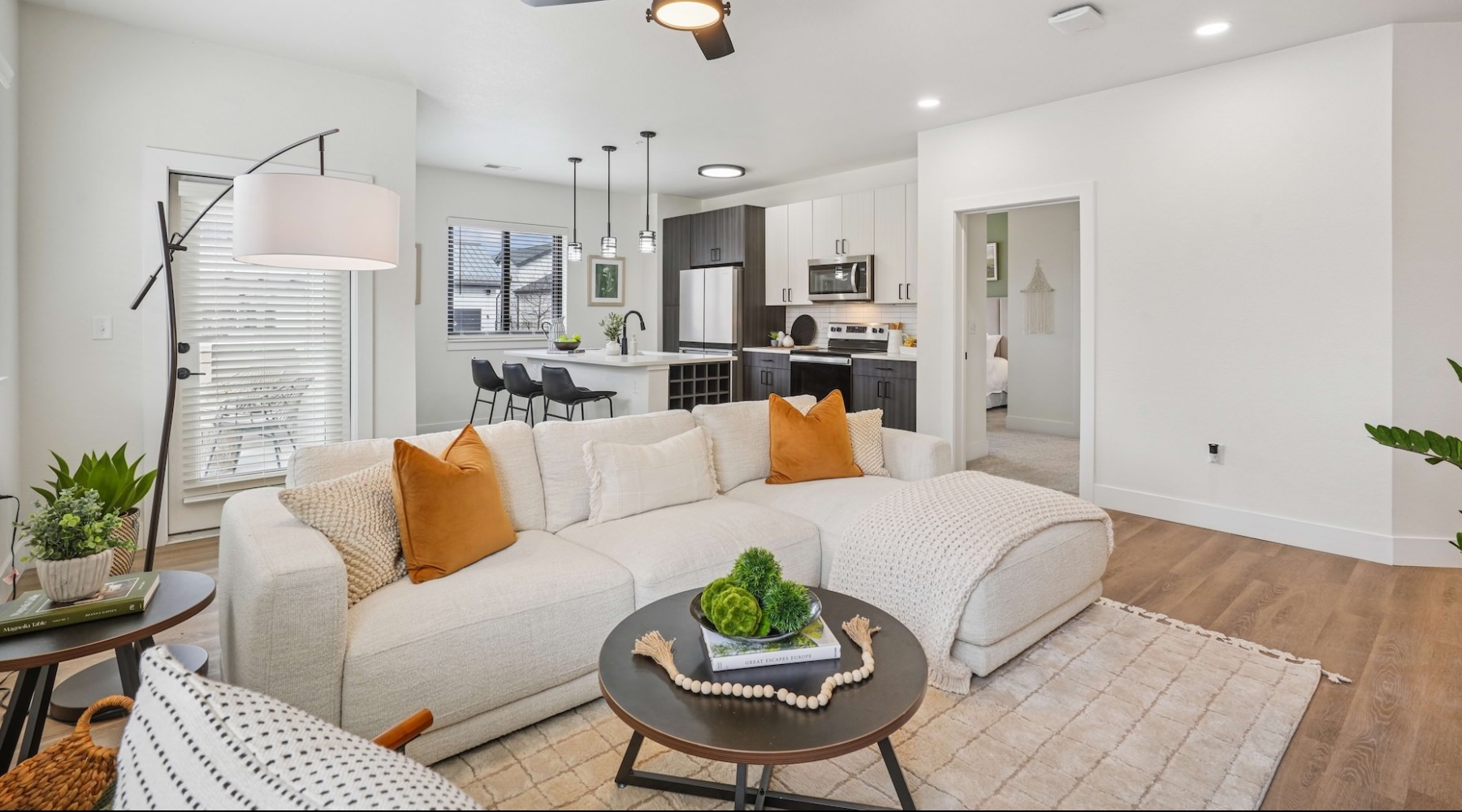  A living room with a white couch and a ceiling fan.