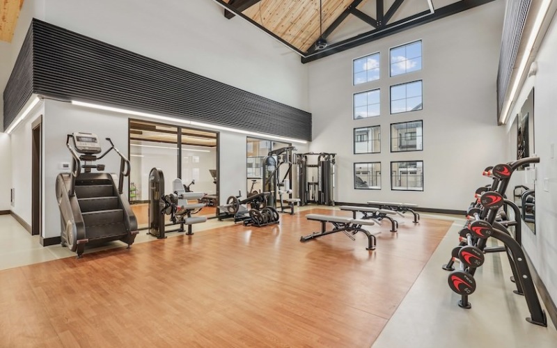 View of the gym with weights, benches, and stair stepper 